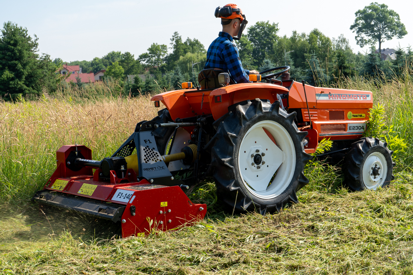 A Remet F1-140-55 flail mower attached to a tractor working through tall grass and dense vegetation. The image shows the mower being used for maintaining fields, rough terrain, and overgrown areas, highlighting the importance of matching a flail mower to the right tractor and application.