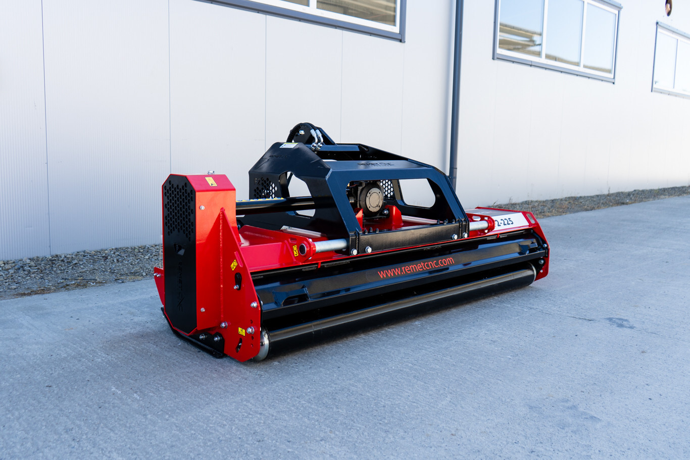 Original product image of a red Remet F2-225 flail mower from Northern Woodsmen, showing the heavy-duty frame, roller and side-shift design.