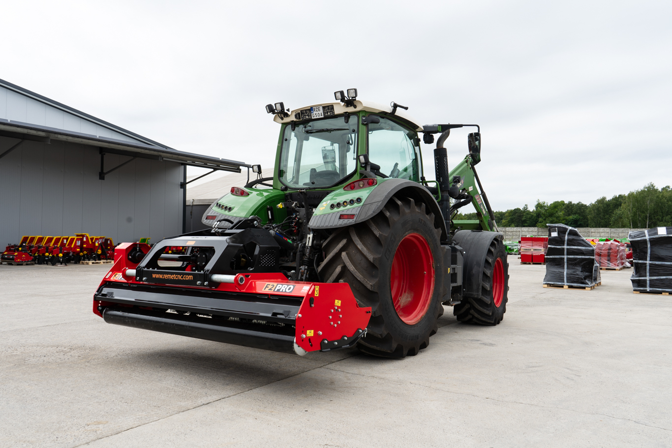 A Remet F2 Pro Series flail mower displayed outside a commercial building, showing its heavy-duty industrial construction and wide working design. The image highlights the robust build, hydraulic side shift system, and large-scale cutting capacity designed for demanding agricultural, municipal, and commercial applications.